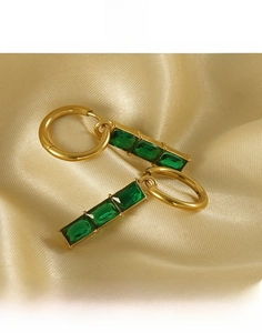 Vue macro détaillée des boucles d'oreilles en titane plaqué or 18K avec zircon vert