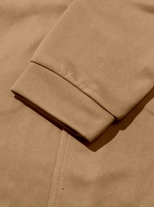 Macro shot of camel knit cardigan sleeve showing rib-knit cuff and cotton fabric texture