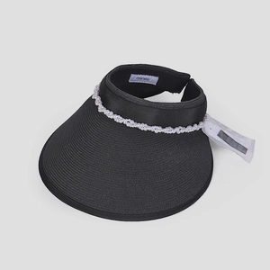 Dettaglio visiera parasole nera intrecciata con perle bianche eleganti ed etichetta