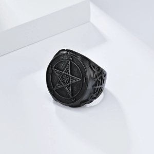 Detail of matte black gothic ring featuring an embossed pentagram satanic symbol