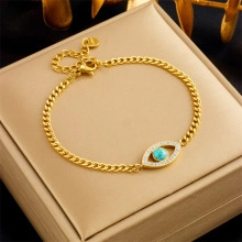 Macro detail of 18K gold evil eye bracelet with turquoise bead and white zircon pavé