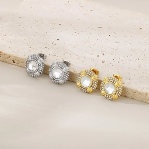 Macro shot of 18k gold and silver stainless steel oval stud earrings with crystals