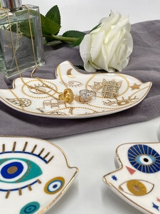 Dettaglio di vassoi per gioielli in ceramica con motivi dorati di Hamsa e malocchio