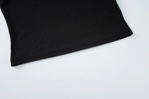 Détail macro de l'ourlet en tricot côtelé avec double couture sur un haut rayé noir élégant