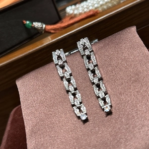 Macro shot of silver chain drop earrings with white cubic zirconia on silk background