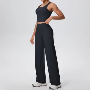 Dettaglio dei pantaloni a gamba larga a vita alta e crop top con sneakers bianche