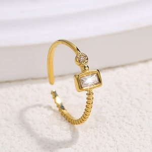 Detailed shot of gold adjustable ring with rectangular zircon and twisted rope texture