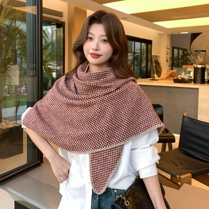 Thick wavy knit red and white checkered scarf shawl for women on a model in a cafe