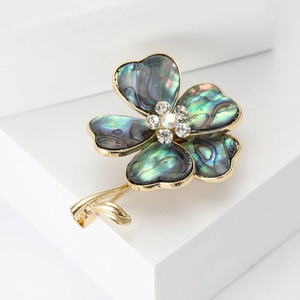 Elegant vintage gold flower brooch with iridescent shell petals and crystal center