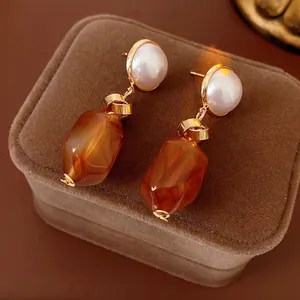 Elegant gold earrings with round pearls and irregular amber resin marble pendants