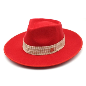 Detailed top view of red wide brim wool fedora hat with beige braided band and metal logo