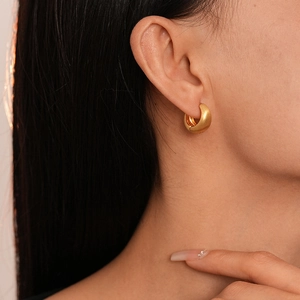 Minimalist matte gold geometric hoop earrings with brushed metal finish on model