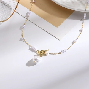 Detail of multi-layer baroque pearl necklace with gold knot clasp and irregular pendant