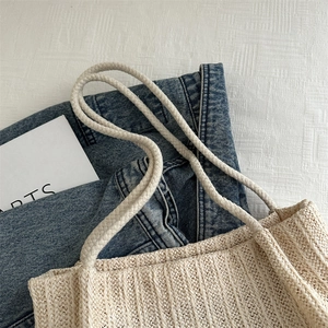 Große beige geflochtene Strohtasche für den Sommer auf Denim-Stoff und einer Kunstkarte