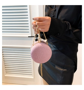 Dettaglio borsa da sera tonda rosa glitterata con manico dorato e tracolla a catena
