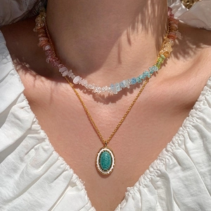 Colorful gemstone beaded necklace set with green enamel pendant on a model