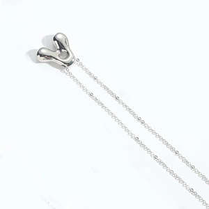 Close-up of polished silver balloon letter Y pendant on minimalist cable chain necklace