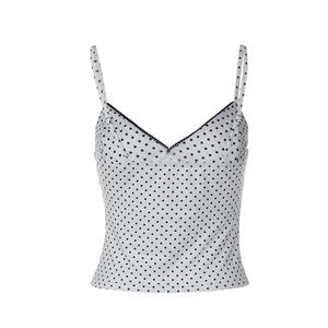 Detail of white polka dot camisole with black lace trim and slim fit design