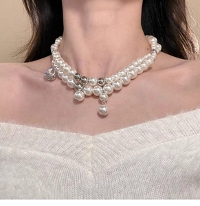 Detail of elegant double-layered pearl necklace with silver beads and crystal pendant