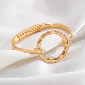 Detailed macro shot of a gold wavy cuff bracelet with geometric spiral wire design