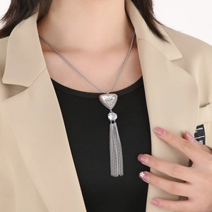 Close-up of silver tassel necklace with triangular and spherical zircon pendant on model