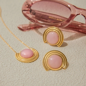 Détail d'un ensemble collier et boucles d'oreilles dorés avec pierres roses luxe