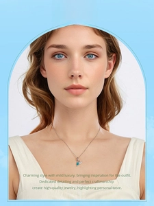 Close-up of elegant swan pendant necklace with blue gemstone worn by a model