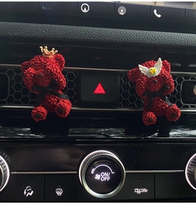 Close-up of red bear air vent clips with rose texture and decorative crowns and wings