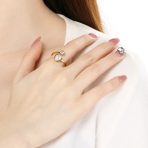 Close-up of heart pearl open ring on model finger with elegant gold finish jewelry