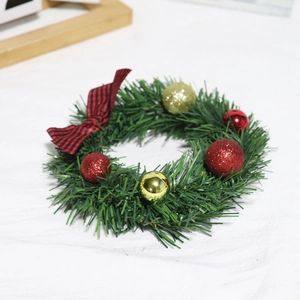 Mini Christmas wreath with green pine branches, red baubles and plaid bow decoration