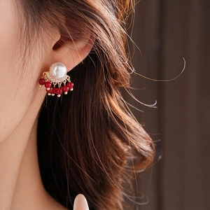 Elegant gold-plated fringe pearl earrings with red rubies shown on model