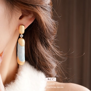 Orecchini pendenti vintage in oro e blu marmorizzato con cristalli indossati da modella