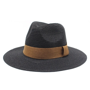 Detailed close-up of a black straw fedora with a flat brim and brown ribbon trim