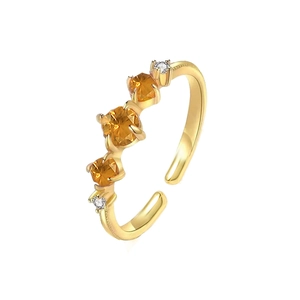 Detail of adjustable gold ring featuring vibrant orange crystals and white diamonds