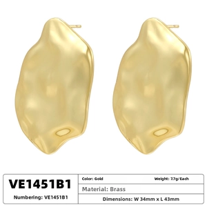 Detailed view of large gold-plated brass earrings featuring irregular lava texture