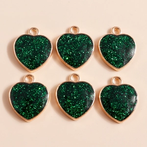 Detail of green heart charms with golden alloy edges and shiny glitter filling
