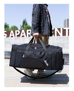 Detail of black Oxford fabric sports bag with white lettering and red quilted side pocket