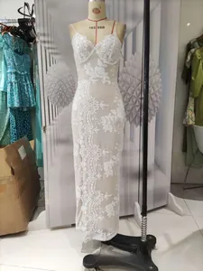 Detail shot of white evening dress featuring intricate floral lace and embroidery texture