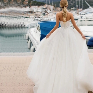 Elegant strapless lace wedding dress with back lace-up detail and layered tulle skirt