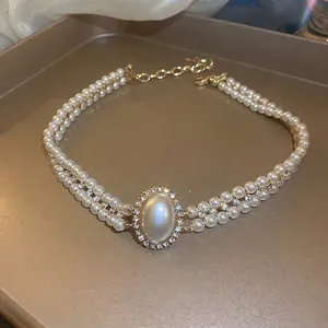 Collier double rang de perles ovales baroques et strass sur un fond de soie élégant