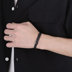 Detail of black stainless steel mesh bracelet on wrist with rectangular metal buckle