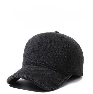Detail of gray wool baseball cap with thermal earflaps and shield-shaped metal logo