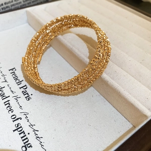 Detail of five-layer gold plated wrap bracelet with textured beads in jewelry tray