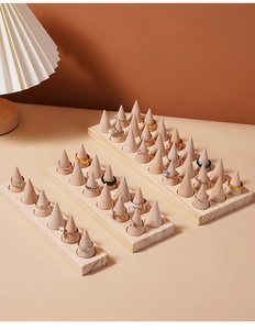 Detailed view of wooden conical ring display stands in various sizes with natural grain texture
