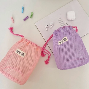 Macro view of mesh drawstring storage bags in pink and purple for cosmetic organization