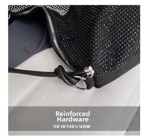Detail of black rhinestone tote bag showing silver zipper and knotted leather handle