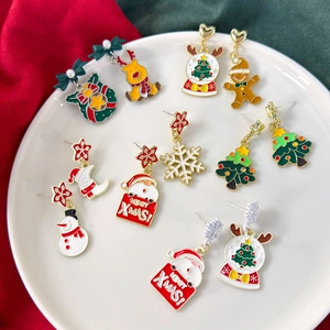 Festive Christmas earring set featuring Santa and reindeer designs on a white plate