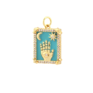 Macro view of 18k gold plated Hamsa hand pendant with turquoise enamel and zircon stones