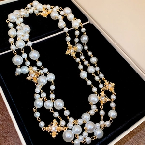 Detailed macro view of French style pearl necklace with gold diamond cross pendant