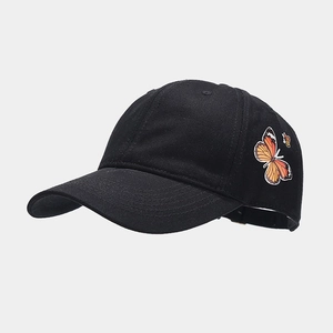 Fashionable black baseball cap with orange butterfly patch in a stylish side view